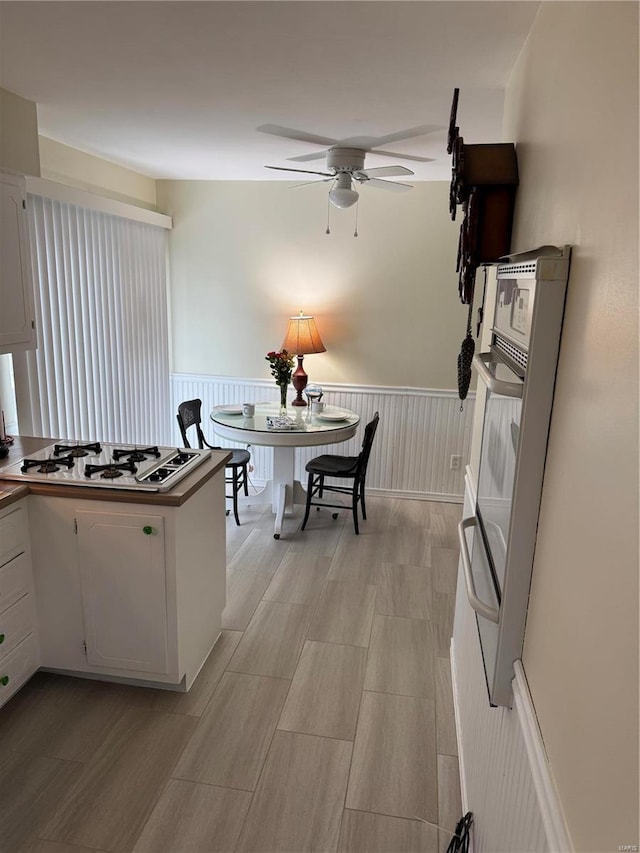 kitchen featuring ceiling fan, white gas cooktop, and white cabinets