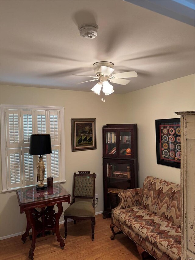 living area with ceiling fan and light hardwood / wood-style floors