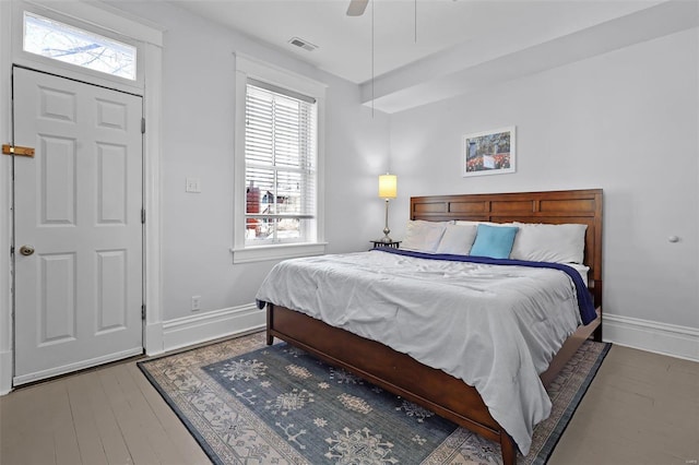 bedroom with multiple windows, wood-type flooring, and ceiling fan