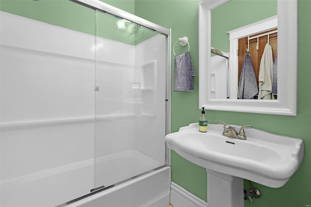 bathroom featuring sink and shower / bath combination with glass door