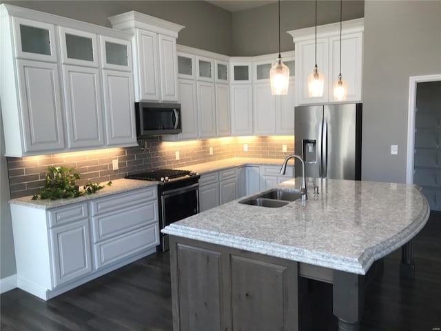 kitchen with sink, a center island with sink, white cabinets, and appliances with stainless steel finishes