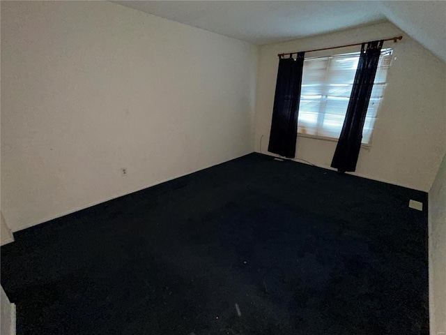 spare room with vaulted ceiling and carpet flooring