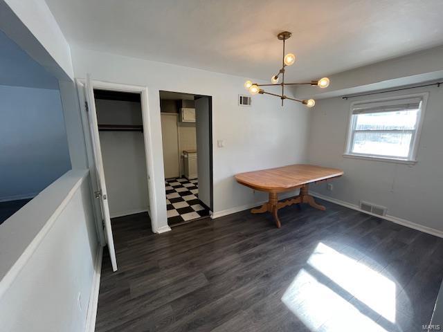 unfurnished dining area with dark hardwood / wood-style flooring and a notable chandelier