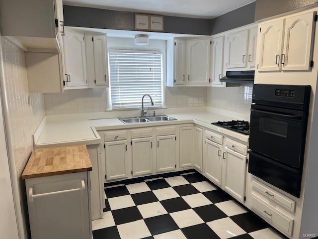 kitchen with white cabinetry, sink, decorative backsplash, and black appliances