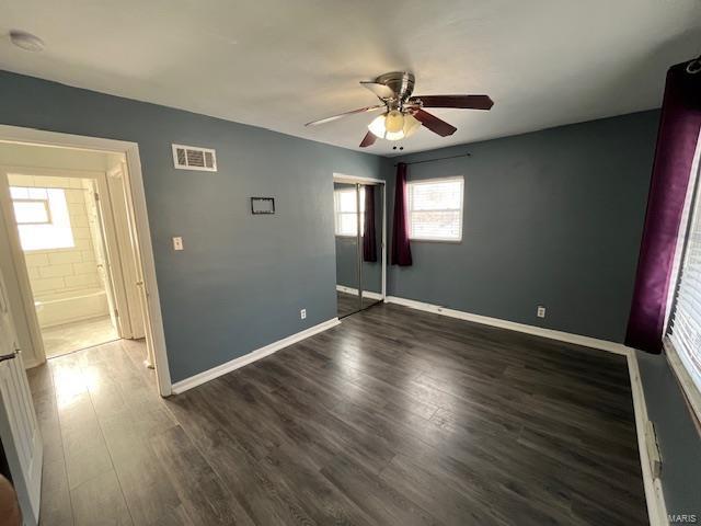 unfurnished bedroom with dark hardwood / wood-style floors, ceiling fan, and a closet