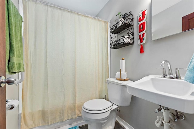 bathroom featuring sink, toilet, and a shower with shower curtain