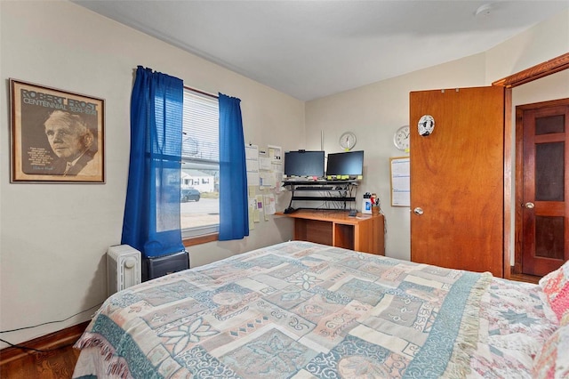 bedroom featuring radiator and hardwood / wood-style flooring