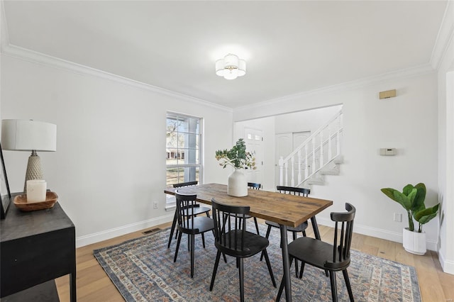 dining area with crown molding and hardwood / wood-style floors