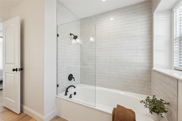 bathroom featuring hardwood / wood-style flooring and tiled shower / bath