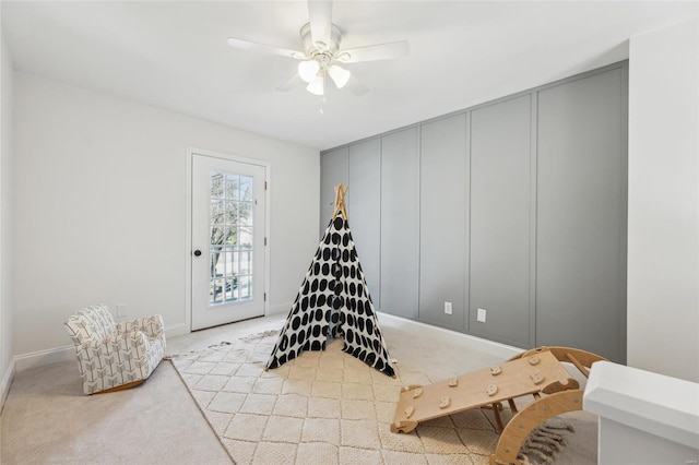 game room featuring light colored carpet and ceiling fan