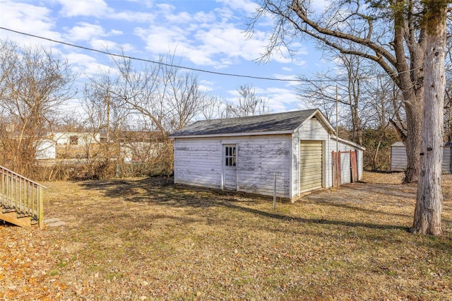 view of outdoor structure featuring a garage and a lawn