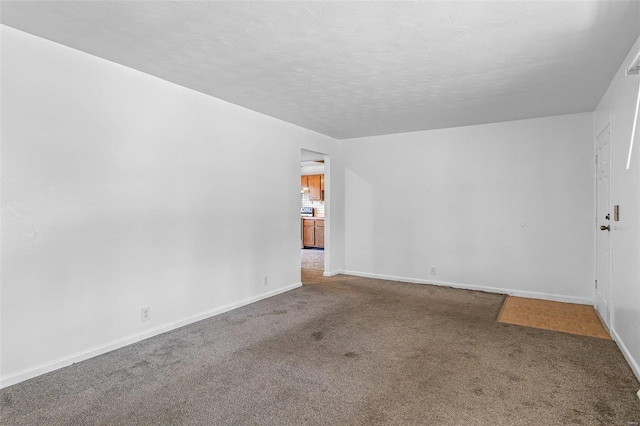 carpeted spare room with a textured ceiling