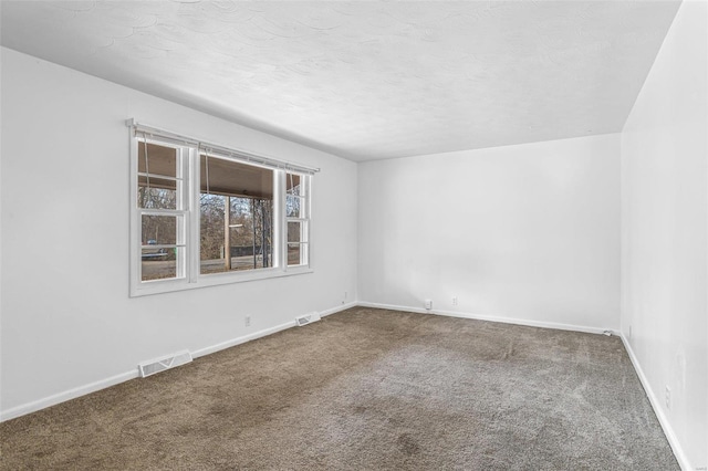 carpeted empty room featuring a textured ceiling