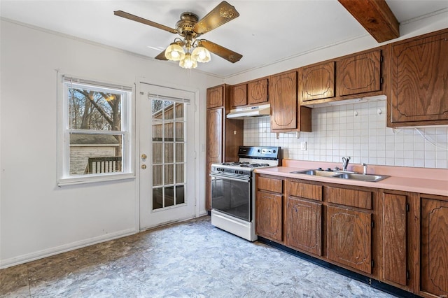 kitchen featuring white range with gas cooktop, sink, ceiling fan, and decorative backsplash