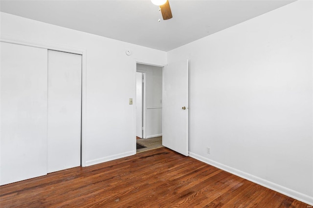 unfurnished bedroom featuring dark wood-type flooring, ceiling fan, and a closet