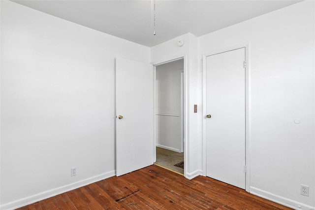 unfurnished bedroom with dark hardwood / wood-style flooring