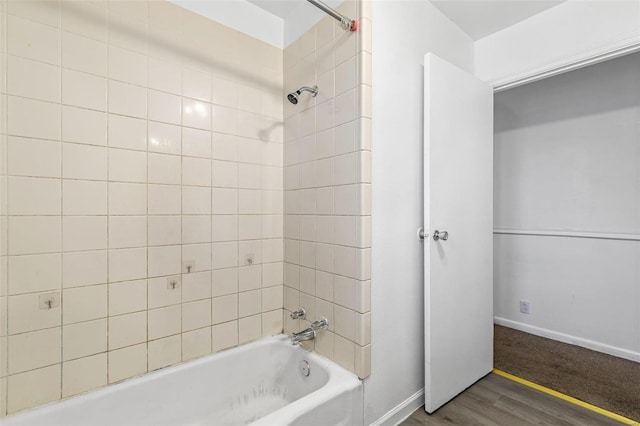 bathroom with hardwood / wood-style flooring and tiled shower / bath