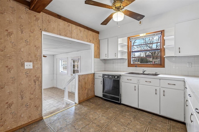 kitchen featuring tasteful backsplash, dishwasher, sink, and white cabinets