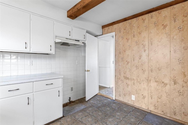 kitchen featuring beamed ceiling and white cabinets