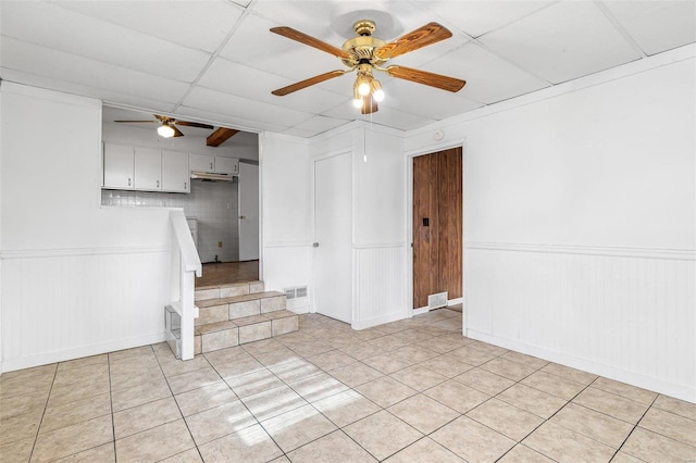 spare room featuring ceiling fan, a paneled ceiling, and light tile patterned floors