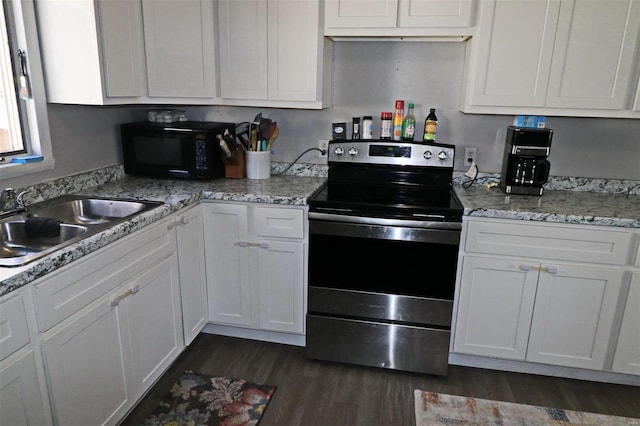 kitchen featuring stainless steel electric range oven, white cabinetry, sink, light stone counters, and dark wood-type flooring