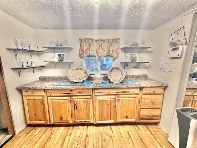 kitchen with a textured ceiling and light wood-type flooring