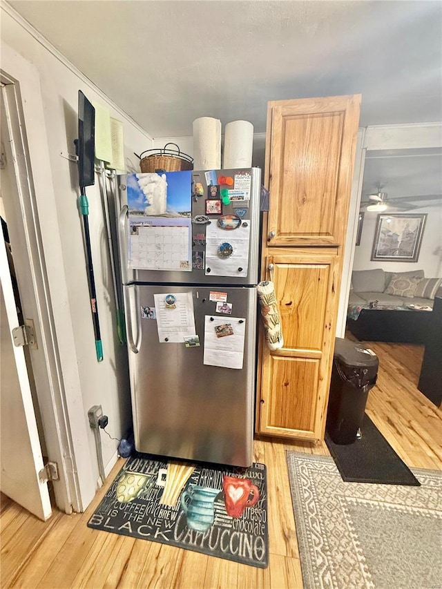 kitchen with light brown cabinets, stainless steel refrigerator, and light hardwood / wood-style floors