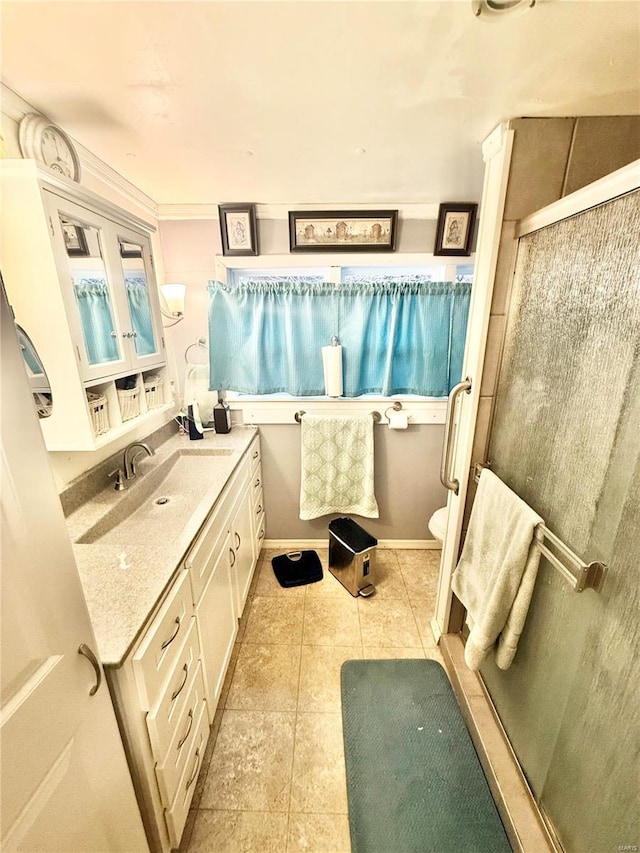 bathroom featuring an enclosed shower, vanity, tile patterned floors, and toilet