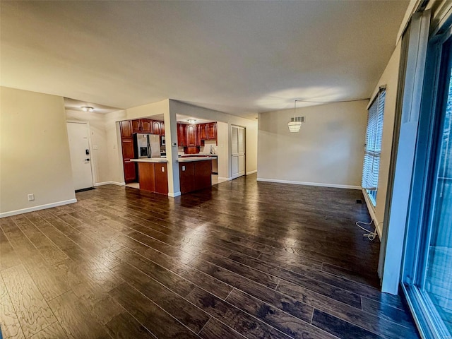 unfurnished living room featuring dark wood-style floors and baseboards