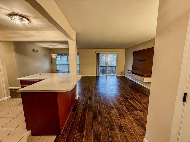 kitchen with baseboards, light countertops, wood finished floors, and open floor plan