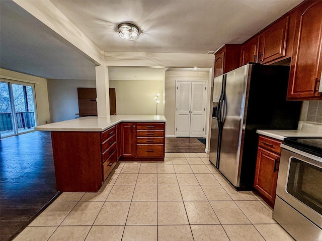 kitchen featuring light tile patterned floors, light countertops, backsplash, and stainless steel electric stove