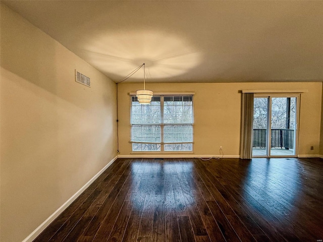 unfurnished dining area featuring dark wood-style floors, baseboards, and visible vents