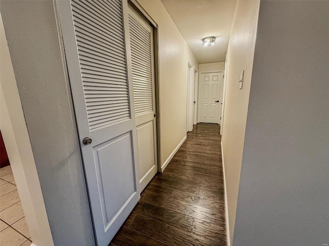 corridor featuring baseboards and wood finished floors