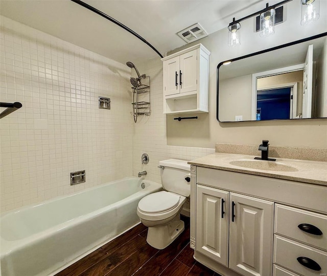 bathroom with shower / washtub combination, visible vents, toilet, vanity, and wood finished floors