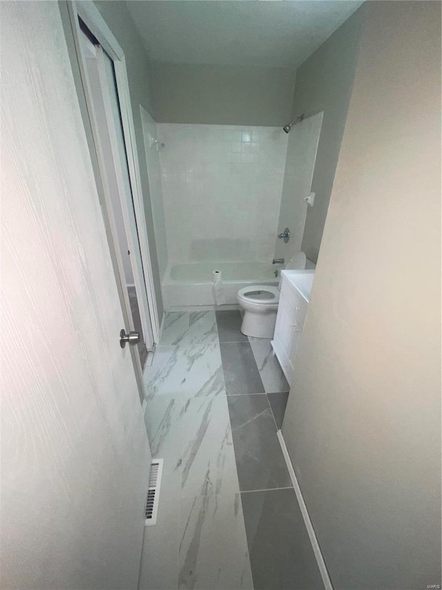 full bathroom with tiled shower / bath, vanity, and toilet