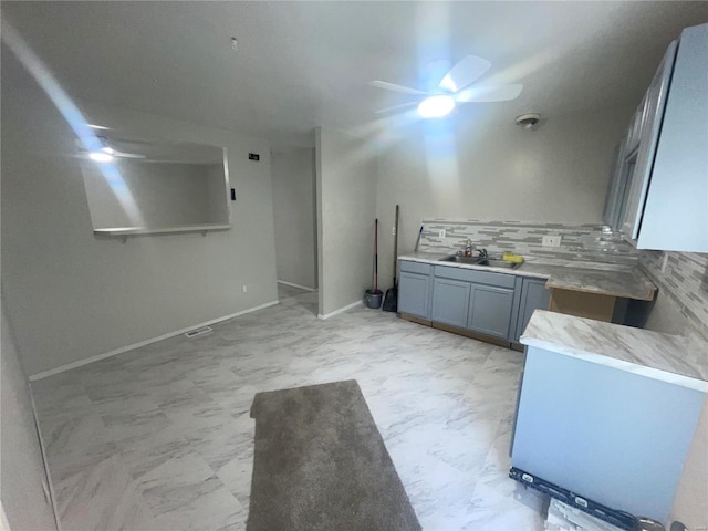 interior space featuring tasteful backsplash, ceiling fan, and sink