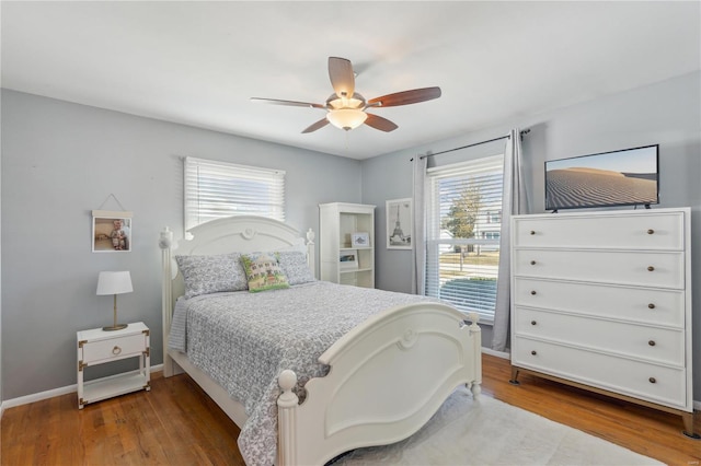 bedroom featuring ceiling fan, baseboards, and wood finished floors