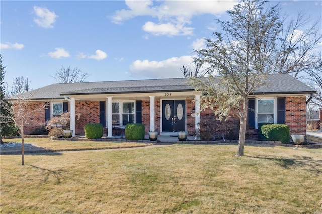 single story home featuring roof with shingles, a front lawn, and brick siding