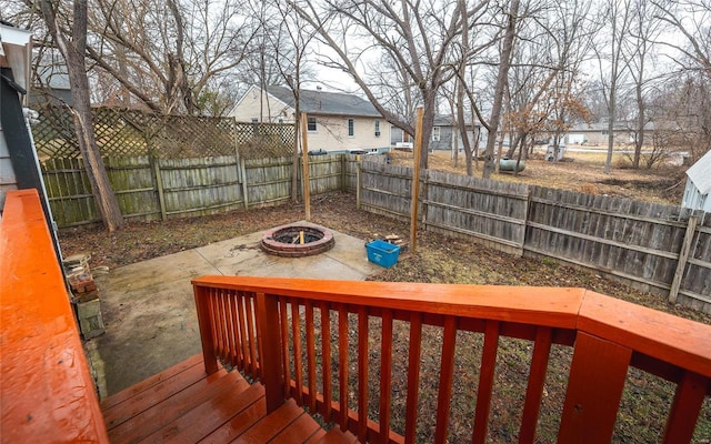 wooden terrace featuring a patio and a fire pit