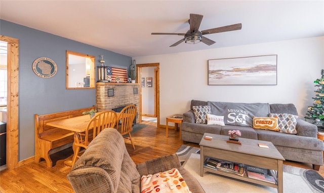 living room with ceiling fan, hardwood / wood-style floors, and a fireplace