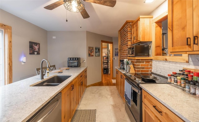 kitchen featuring stainless steel appliances, tasteful backsplash, sink, and ceiling fan