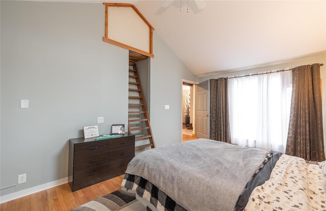 bedroom featuring light hardwood / wood-style flooring, ceiling fan, and vaulted ceiling