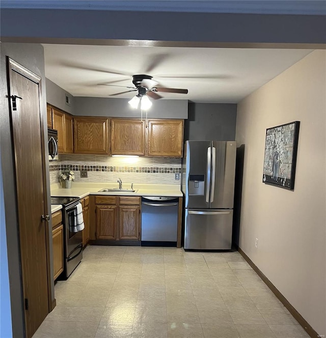 kitchen featuring ceiling fan, stainless steel appliances, sink, and decorative backsplash