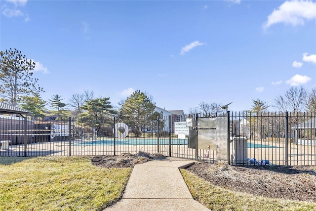 view of gate with a community pool and fence