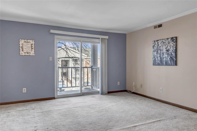 spare room with baseboards, carpet floors, visible vents, and crown molding