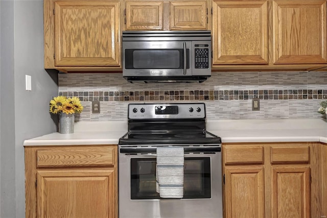 kitchen with stainless steel appliances, light countertops, and decorative backsplash