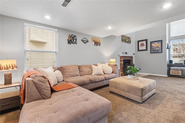 carpeted living room featuring a brick fireplace and a textured ceiling