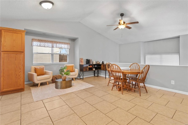 dining room featuring lofted ceiling, a textured ceiling, ceiling fan, and light tile patterned flooring