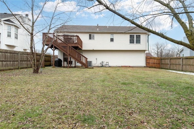 rear view of property featuring central AC unit, a deck, and a lawn