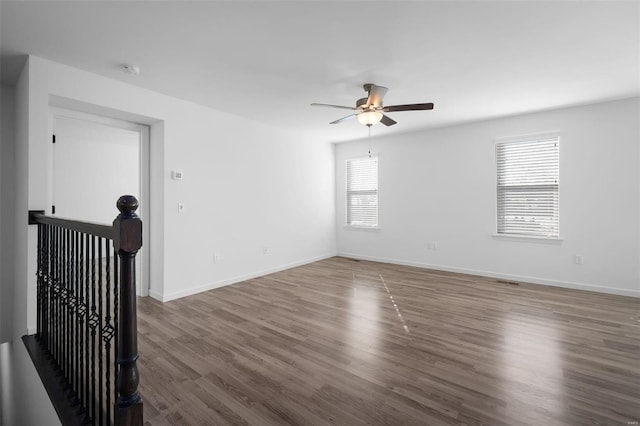 empty room featuring dark wood-type flooring and ceiling fan